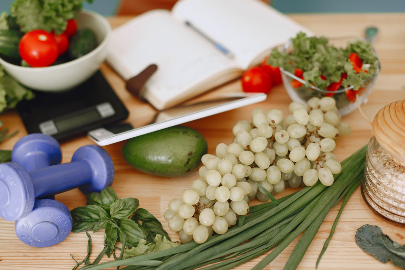 Metabolic wellness and weight management at Suncare Medical Clinic in Irvine, with healthy salad, food scale, journal and dumbbells
